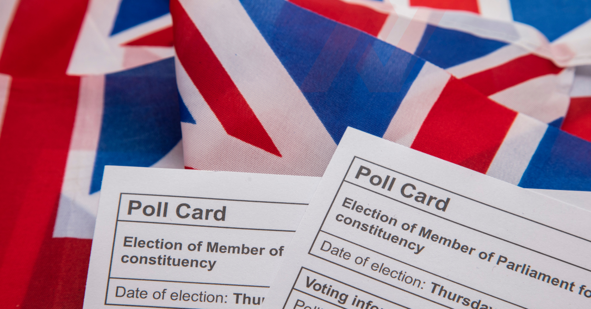 Photo of polling cards with union jack flag in the background. 