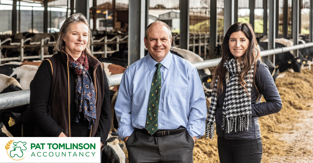 Wide angle shot of Pat Tomlinson and two of his colleagues against a farming backdrop. 